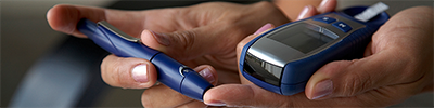 A person checking their blood with a glucose meter.