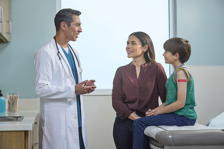 Doctor with preeteen boy and mother