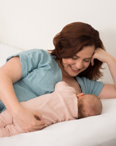 photo of mother and baby lying on a bed