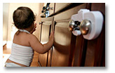 Baby next to a locked cabinet.