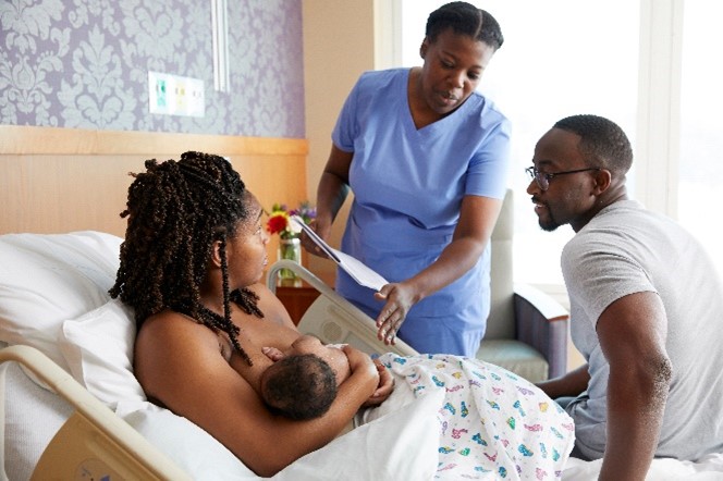 Mother, Father with their baby talking to a nurse.