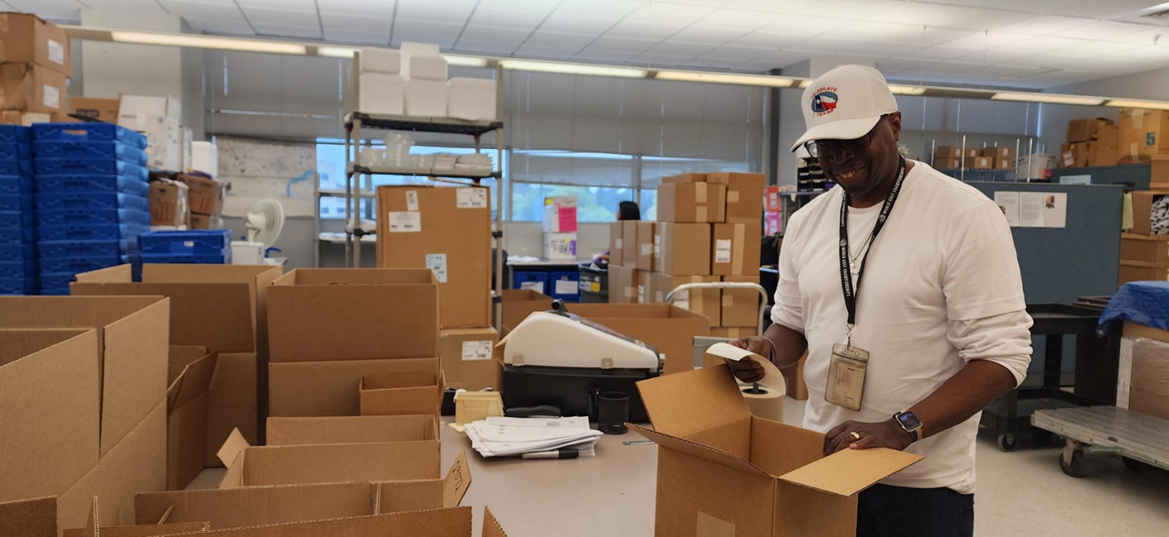 A person in a white hat looking at boxes.