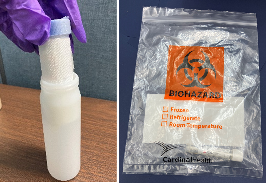 A closed, transparent plastic biohazard bag lays on a table top. A large orange "Biohazard" symbol 