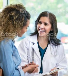 Una doctora hablando con un paciente.