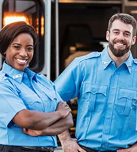 Smiling paramedics by an emergency vehicle