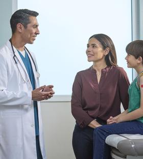 Doctor with preeteen boy and mother