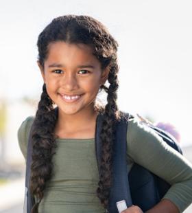 Niña de escuela primaria llevando mochila