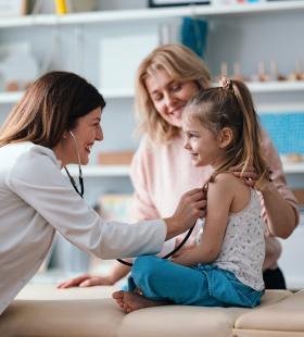 Doctor examining a child with their parent