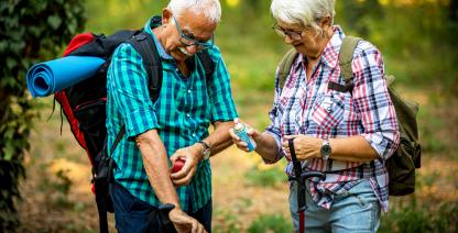 Una pareja de excursionistas aplica repelente de mosquitos.