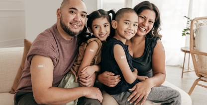 Una familia sonriente con vendas de vacunas.