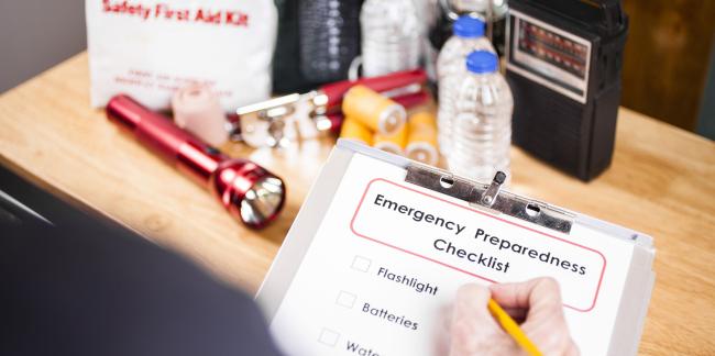 Una persona que usa una lista de verificación de preparación para emergencias