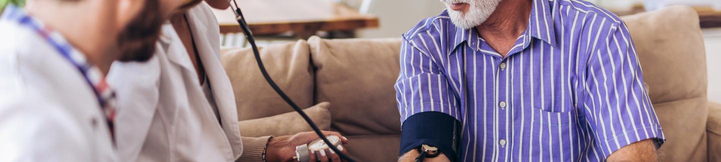 Nurse measuring blood pressure of a senior man