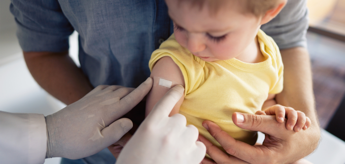 A child gets a Band-Aid after a vaccine.