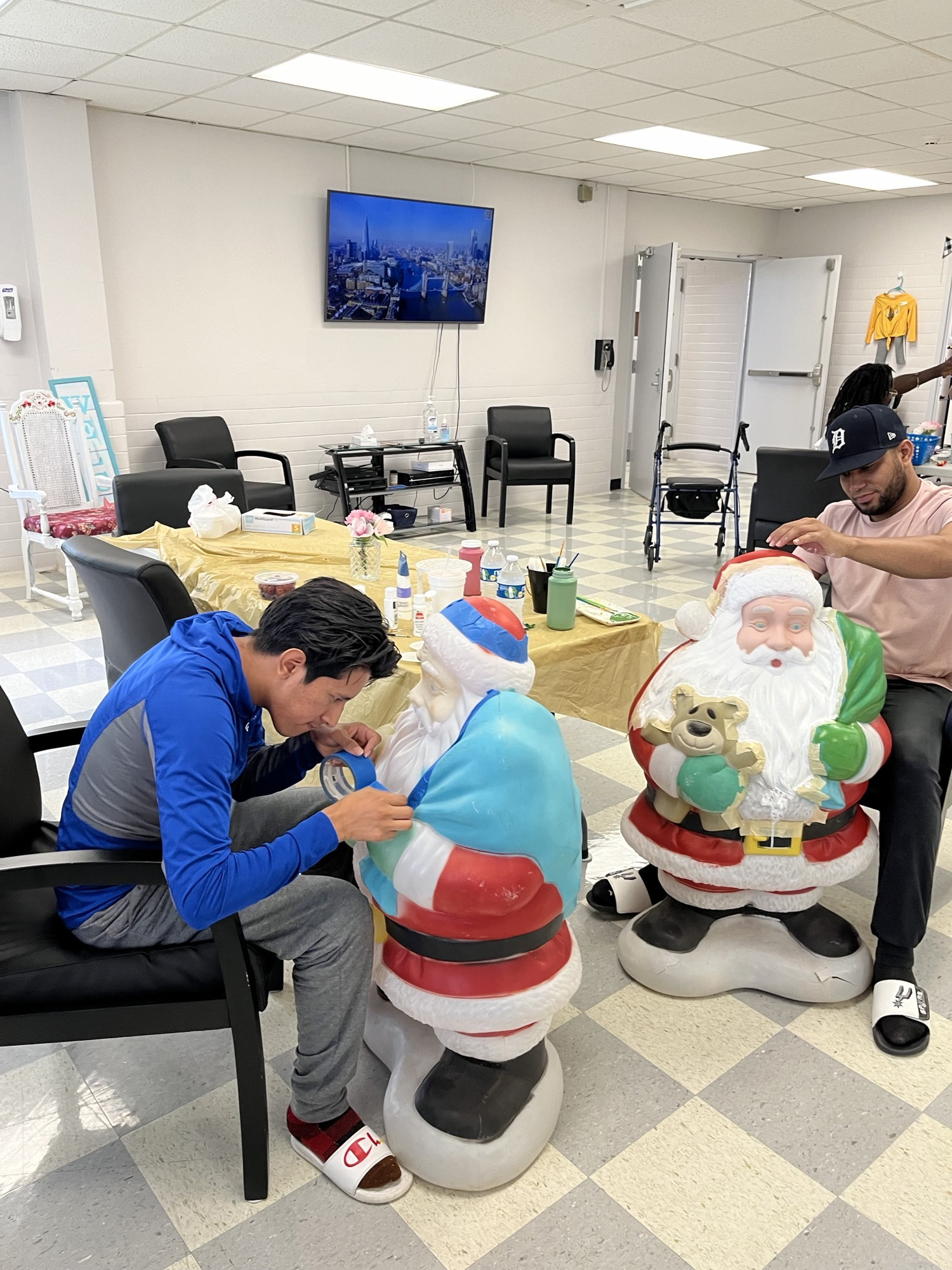 Two patients paint Christmas themed statues