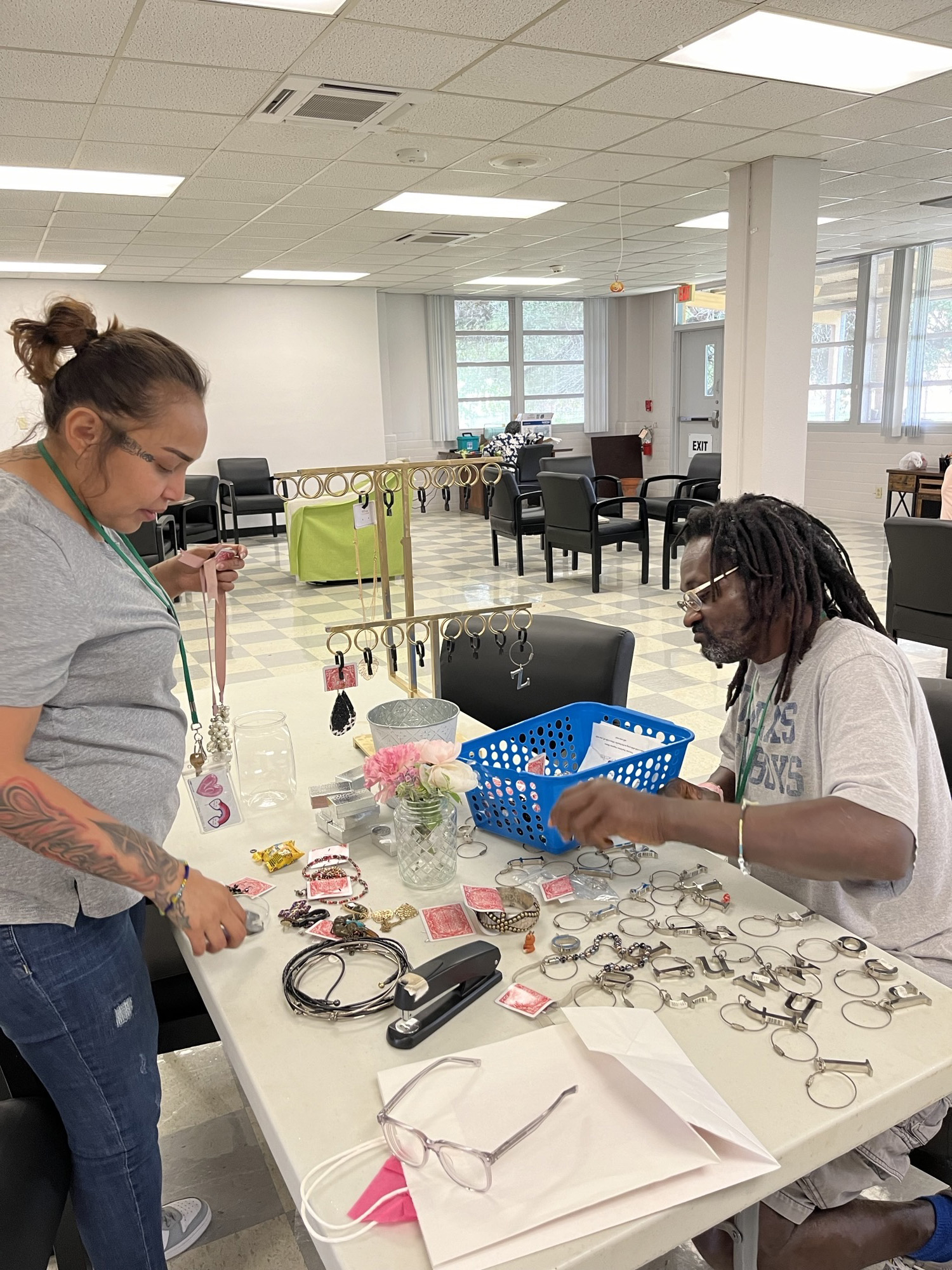 A man and a woman sort jewelry on a table 