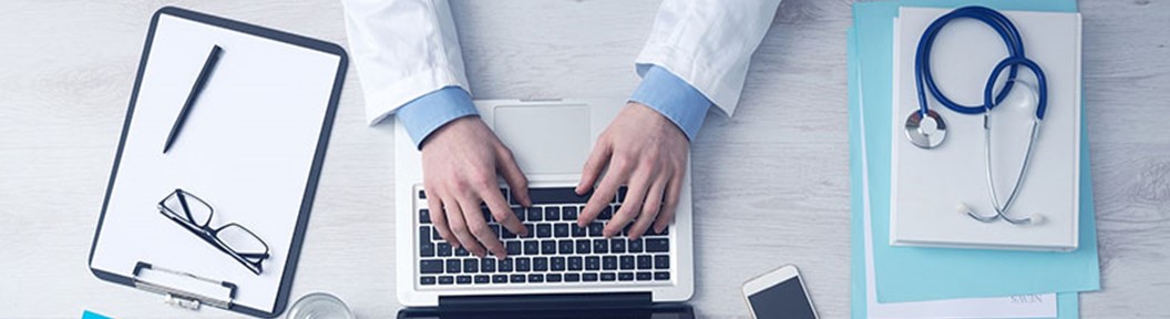 Hands extending from a white coat reaching to a laptop, decorative