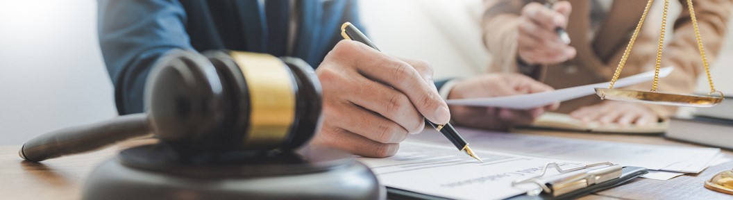 Image of a hand next to a gavel, decorative
