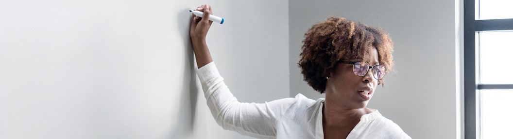 Image of an African-American adult write on a dry erase board, decorative