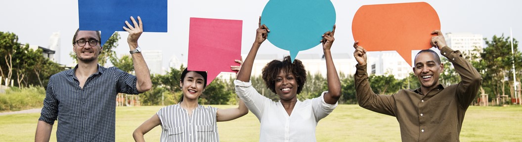 People in a field holding up boards like cartoon speaking shapes, decorative