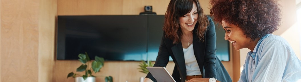 Image of two women talking while looking at a laptop, decorative