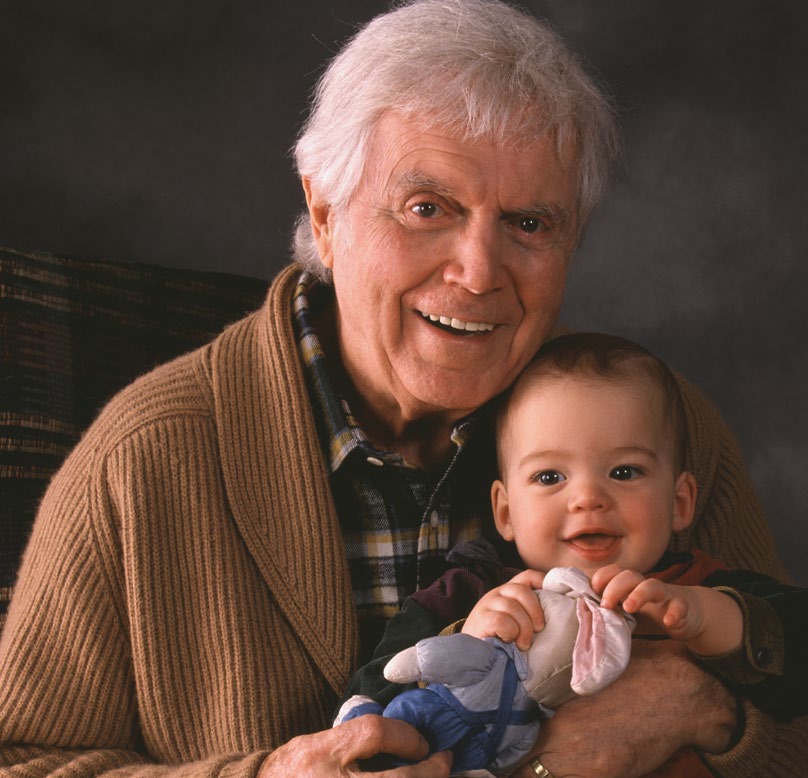 Elderly man holds baby