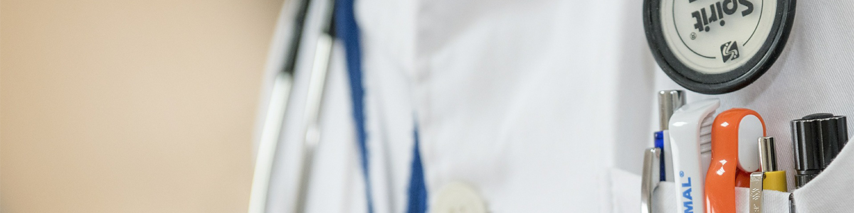 A person wears a white doctor coat with a stethoscope.