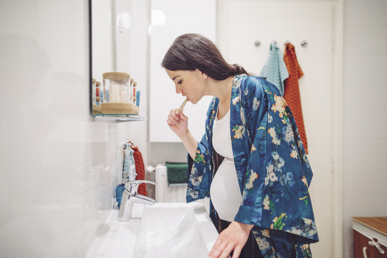 pregnant person brushing teeth