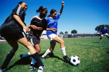 three girls playing soccer