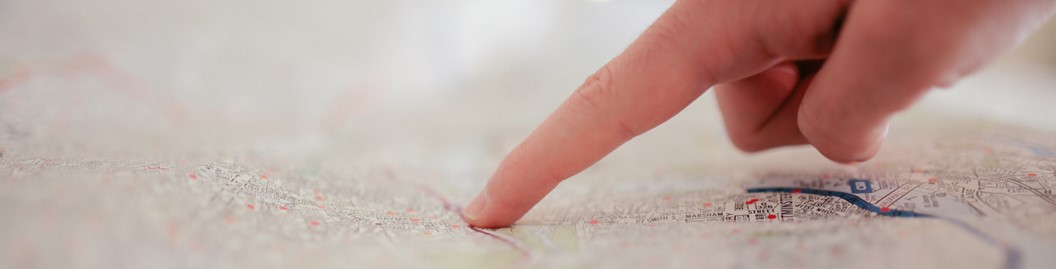 A finger pointing to an area on a map