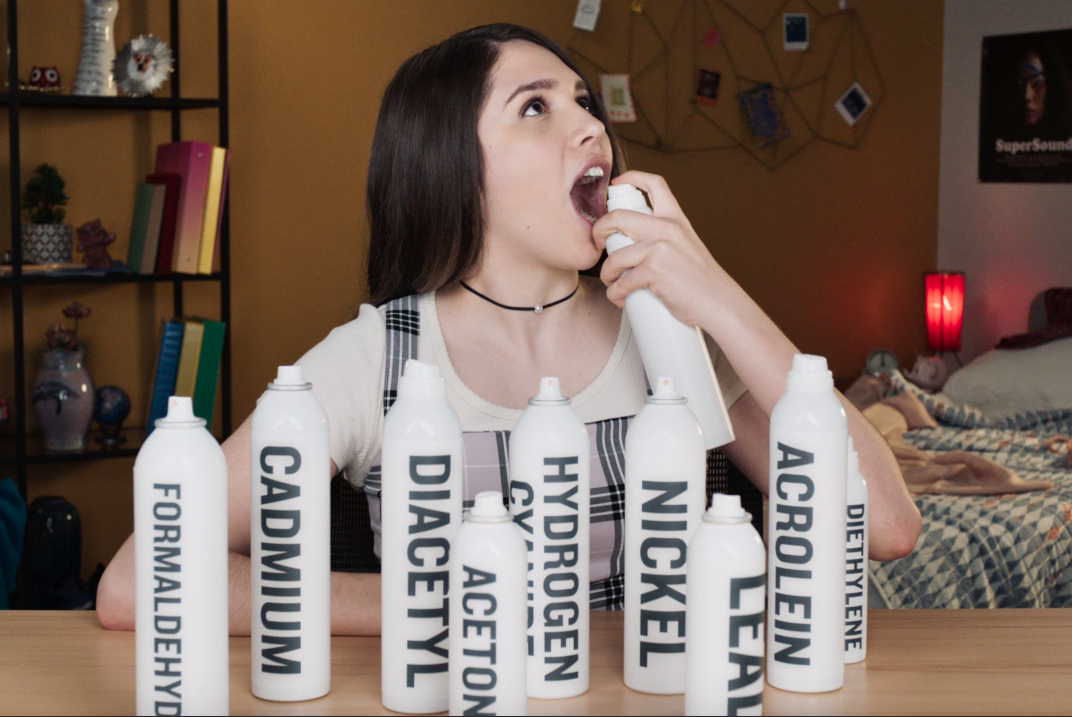 Niña rociando productos químicos en su boca